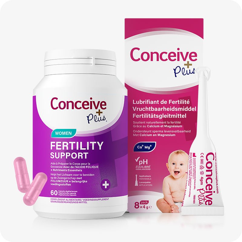 Conceive Plus Women's Fertility Support + Applicators (FR) product image displaying a white and purple bottle of women fertility support capsules alongside an 8x4g pre-filled fertility lubricant applicators box, with French, Dutch, and German language text on packaging and a baby graphic; pink capsules and one applicator are also visible in foreground on a white background.
